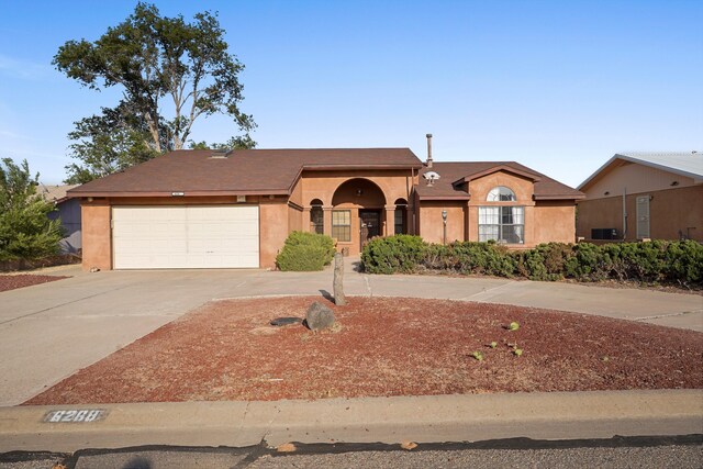 6268 Apache Plume Rd NE, Rio Rancho, NM 87144 - ranch-style home with driveway, an attached garage, stucco siding, and a shingled roof