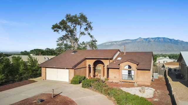 6268 Apache Plume Rd NE, Rio Rancho, NM 87144 - view of front facade with a mountain view, concrete driveway, an attached garage, and stucco siding