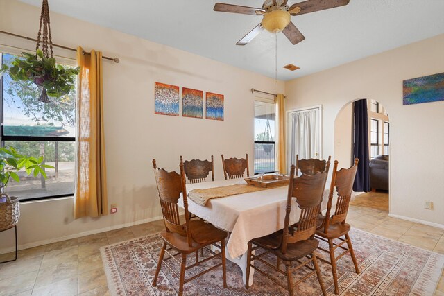 6268 Apache Plume Rd NE, Rio Rancho, NM 87144 - dining space with healthy amount of natural light, a ceiling fan, arched walkways, and light tile patterned floors