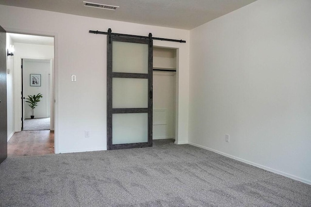 4441 Kellia Ln NE, Albuquerque, NM 87111 - unfurnished bedroom featuring a barn door, carpet floors, and a closet