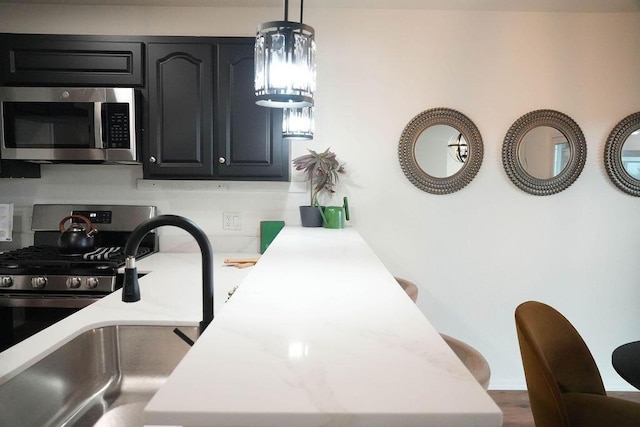 4441 Kellia Ln NE, Albuquerque, NM 87111 - kitchen with appliances with stainless steel finishes, light countertops, decorative light fixtures, and a peninsula