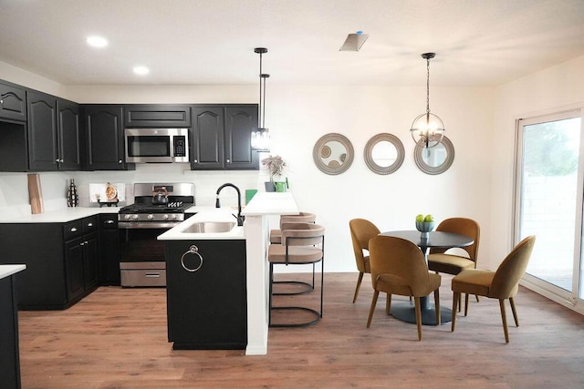 4441 Kellia Ln NE, Albuquerque, NM 87111 - kitchen with appliances with stainless steel finishes, a kitchen breakfast bar, plenty of natural light, light wood finished floors, and recessed lighting