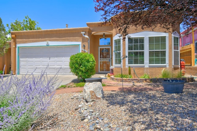 6749 Kelly Ann Rd NE, Albuquerque, NM 87109 - view of front of house with stucco siding, driveway, and a garage