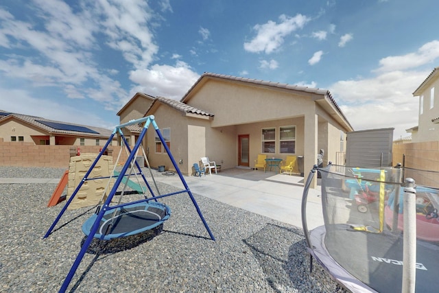 1854 Valle Vista Rd NW, Los Lunas, NM 87031 - back of property featuring a playground, stucco siding, a fenced backyard, and a patio area
