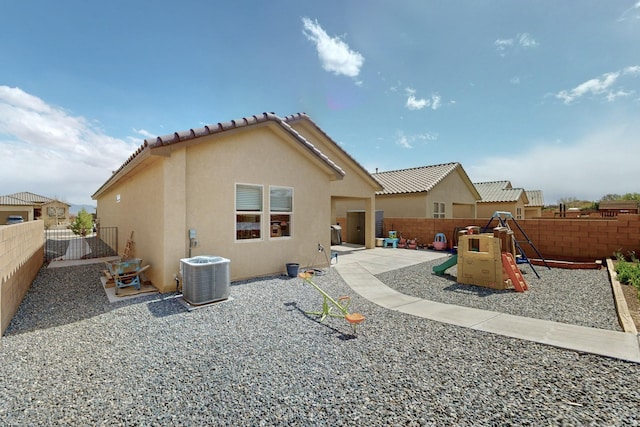 1854 Valle Vista Rd NW, Los Lunas, NM 87031 - back of property with stucco siding, a playground, a fenced backyard, and a patio