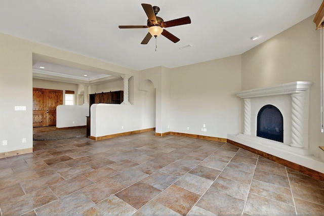 2413 Desert View Rd NE, Rio Rancho, NM 87144 - unfurnished living room with a ceiling fan, a fireplace with raised hearth, recessed lighting, ornate columns, and stone finish floors