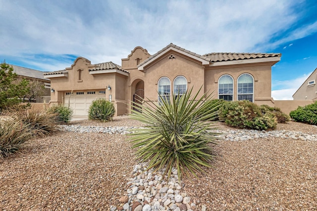 2413 Desert View Rd NE, Rio Rancho, NM 87144 - mediterranean / spanish-style house with stucco siding, an attached garage, and a tile roof