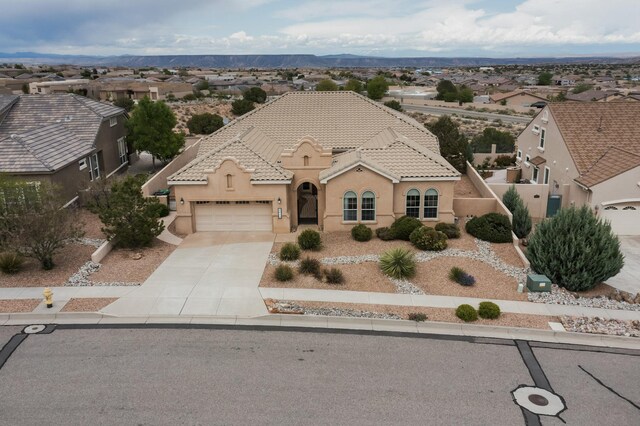2413 Desert View Rd NE, Rio Rancho, NM 87144 - mediterranean / spanish house with a garage, driveway, stucco siding, a tiled roof, and a residential view
