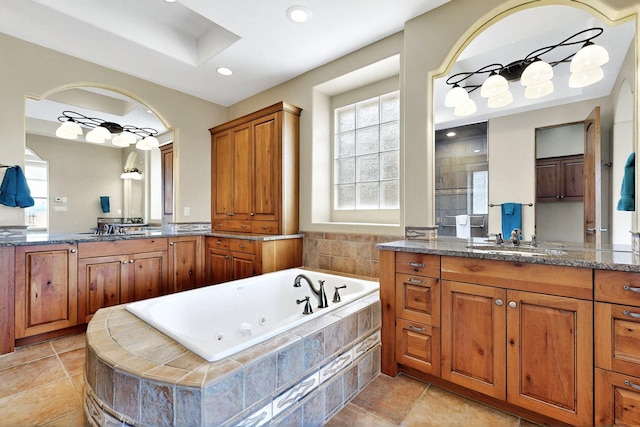 2413 Desert View Rd NE, Rio Rancho, NM 87144 - full bath with a jetted tub, plenty of natural light, two vanities, tiled shower, and recessed lighting