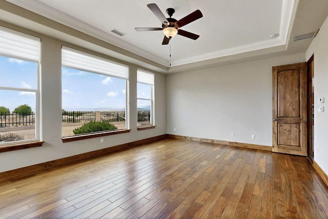 2413 Desert View Rd NE, Rio Rancho, NM 87144 - spare room featuring a tray ceiling, a ceiling fan, wood-type flooring, and crown molding