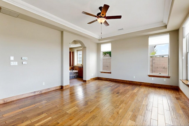 2413 Desert View Rd NE, Rio Rancho, NM 87144 - empty room with a tray ceiling, light wood finished floors, arched walkways, ceiling fan, and crown molding