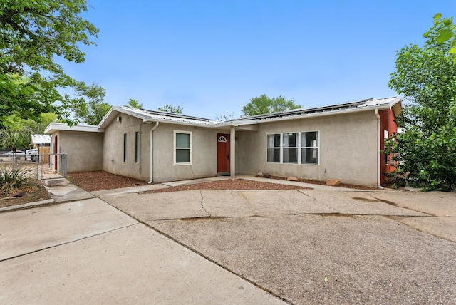 6205 Darlene Pl SW, Albuquerque, NM 87105 - view of front of home with stucco siding, roof mounted solar panels, and a gate