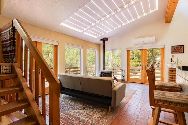 23 Cooper Rd, Cedar Crest, NM 87008 - living room featuring a wood stove, an AC wall unit, brick flooring, vaulted ceiling, and plenty of natural light
