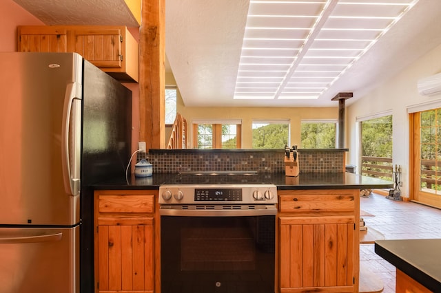 23 Cooper Rd, Cedar Crest, NM 87008 - kitchen with appliances with stainless steel finishes, dark countertops, decorative backsplash, and an AC wall unit
