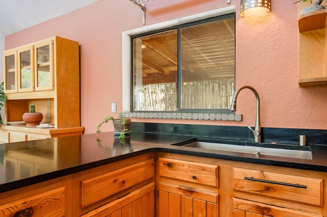 23 Cooper Rd, Cedar Crest, NM 87008 - kitchen featuring a textured wall, dark countertops, glass insert cabinets, and brown cabinets