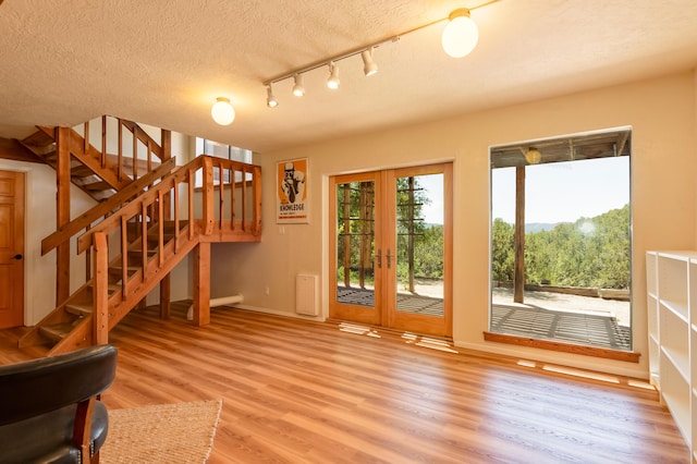 23 Cooper Rd, Cedar Crest, NM 87008 - unfurnished living room featuring stairway, wood finished floors, rail lighting, and a textured ceiling