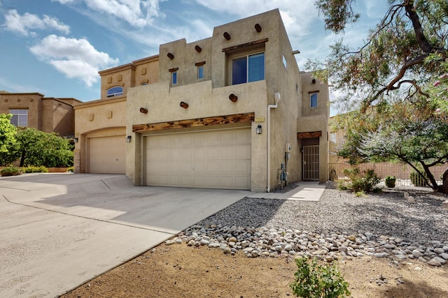 2353 Cortina Loop SE, Rio Rancho, NM 87124 - adobe home featuring an attached garage, stucco siding, and concrete driveway
