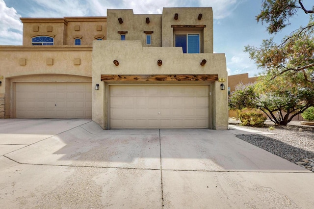 2353 Cortina Loop SE, Rio Rancho, NM 87124 - pueblo-style home with an attached garage, driveway, and stucco siding