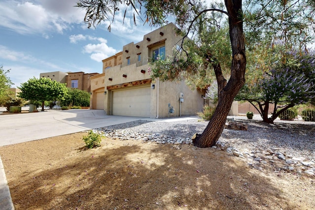 2353 Cortina Loop SE, Rio Rancho, NM 87124 - view of side of property with stucco siding, driveway, and a garage