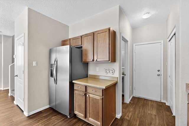 2353 Cortina Loop SE, Rio Rancho, NM 87124 - kitchen with stainless steel refrigerator with ice dispenser, a textured ceiling, dark wood-style flooring, brown cabinetry, and light countertops