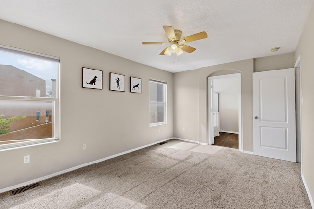 2353 Cortina Loop SE, Rio Rancho, NM 87124 - unfurnished bedroom featuring carpet floors, a ceiling fan, and arched walkways