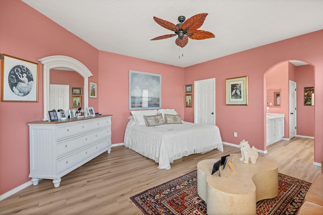 309 Calle Evangeline, Bernalillo, NM 87004 - bedroom featuring arched walkways, light wood-style floors, ceiling fan, and ensuite bath