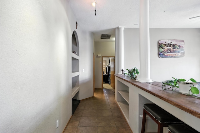 8500 Clarks Fork Rd NW, Albuquerque, NM 87120 - corridor with decorative columns, tile patterned floors, and a textured ceiling