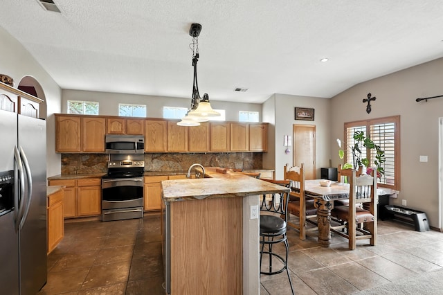 8500 Clarks Fork Rd NW, Albuquerque, NM 87120 - kitchen featuring stainless steel appliances, backsplash, decorative light fixtures, a kitchen island with sink, and recessed lighting