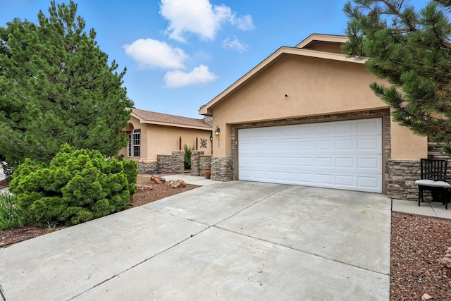 8500 Clarks Fork Rd NW, Albuquerque, NM 87120 - view of front of house featuring stucco siding, stone siding, concrete driveway, and an attached garage