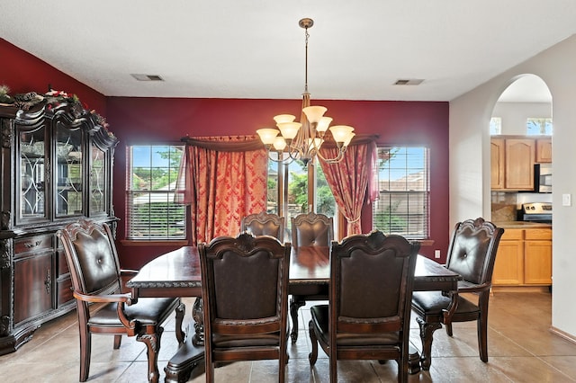 8500 Clarks Fork Rd NW, Albuquerque, NM 87120 - dining area featuring a chandelier, plenty of natural light, arched walkways, and light tile patterned floors