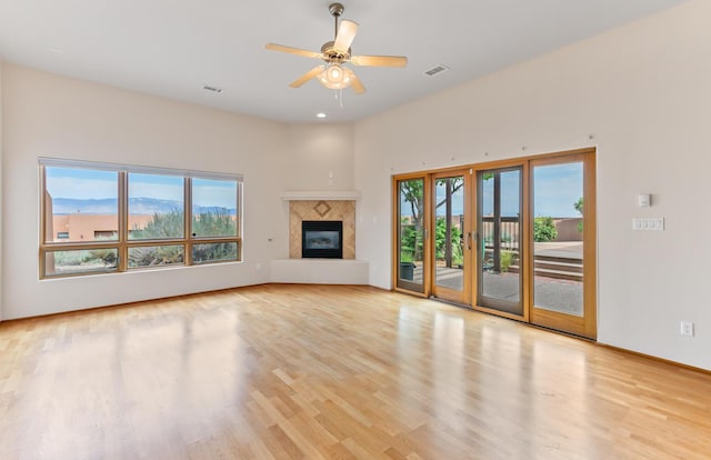 31 Wind Rd NW, Albuquerque, NM 87120 - unfurnished living room with light wood-style floors, ceiling fan, and a glass covered fireplace