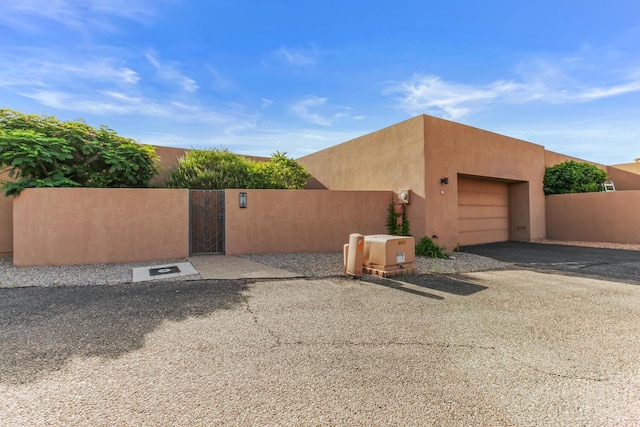 31 Wind Rd NW, Albuquerque, NM 87120 - view of side of property with an attached garage, a gate, driveway, and stucco siding