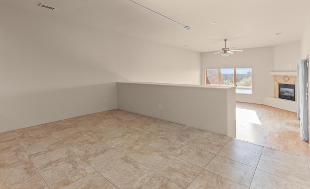 31 Wind Rd NW, Albuquerque, NM 87120 - empty room featuring a ceiling fan and a tile fireplace
