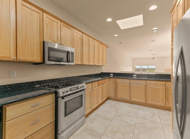 31 Wind Rd NW, Albuquerque, NM 87120 - kitchen featuring appliances with stainless steel finishes, light brown cabinets, a skylight, light tile patterned floors, and recessed lighting