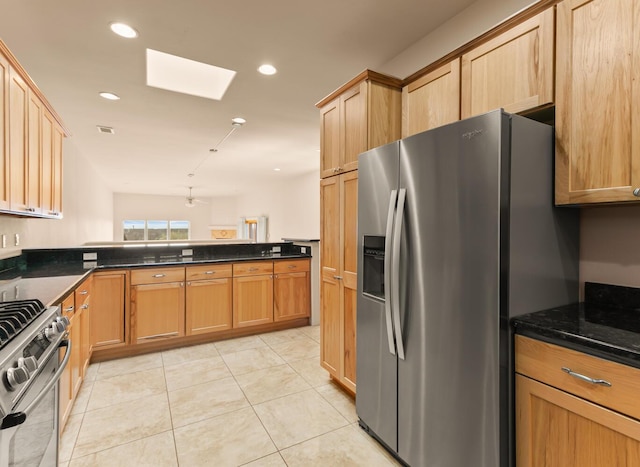 31 Wind Rd NW, Albuquerque, NM 87120 - kitchen with stainless steel appliances, a skylight, light tile patterned floors, dark stone counters, and recessed lighting