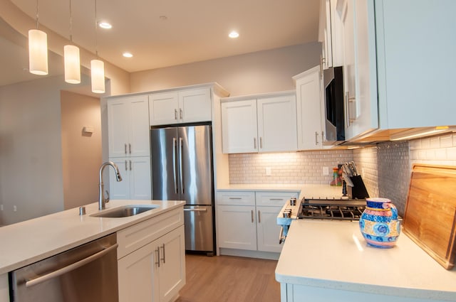 3600 Central Ave SE Unit 202, Albuquerque, NM 87108 - kitchen with appliances with stainless steel finishes, light countertops, tasteful backsplash, white cabinetry, and hanging light fixtures