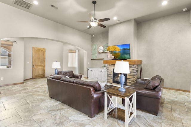 9844 Cameron St NW, Albuquerque, NM 87114 - living area with stone tile flooring, arched walkways, a ceiling fan, recessed lighting, and a stone fireplace