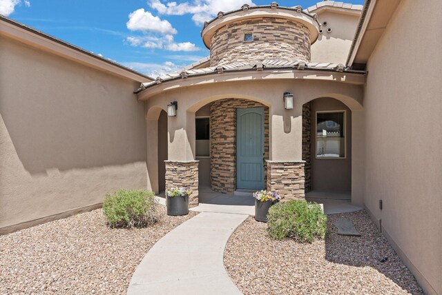 9844 Cameron St NW, Albuquerque, NM 87114 - doorway to property with stucco siding, a porch, a tiled roof, and stone siding