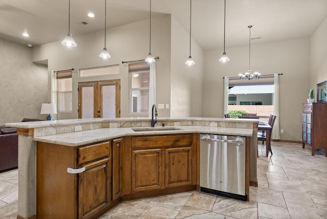 9844 Cameron St NW, Albuquerque, NM 87114 - kitchen with dishwasher, open floor plan, a high ceiling, stone tile flooring, and a chandelier