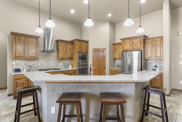 9844 Cameron St NW, Albuquerque, NM 87114 - kitchen featuring appliances with stainless steel finishes, wall chimney exhaust hood, brown cabinetry, a towering ceiling, and a spacious island