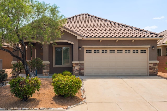 827 Purple Aster Dr, Bernalillo, NM 87004 - view of front of house featuring driveway, stone siding, an attached garage, stucco siding, and a tile roof