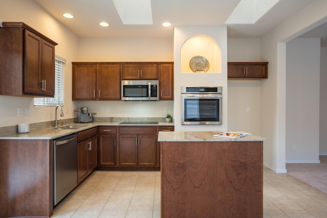 827 Purple Aster Dr, Bernalillo, NM 87004 - kitchen with appliances with stainless steel finishes, a skylight, light stone countertops, a center island, and light tile patterned floors