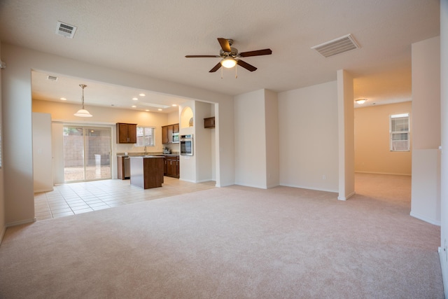 827 Purple Aster Dr, Bernalillo, NM 87004 - unfurnished living room with light carpet, ceiling fan, and recessed lighting