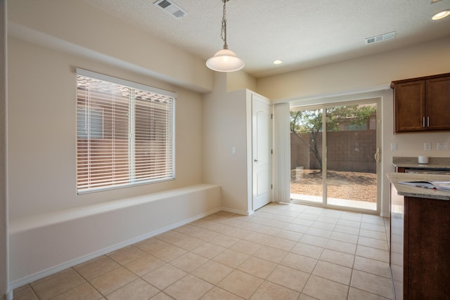 827 Purple Aster Dr, Bernalillo, NM 87004 - unfurnished dining area with light tile patterned floors, a textured ceiling, and recessed lighting