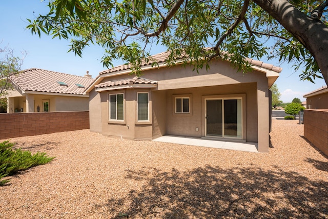 827 Purple Aster Dr, Bernalillo, NM 87004 - back of house featuring stucco siding, a fenced backyard, a tile roof, and a patio area