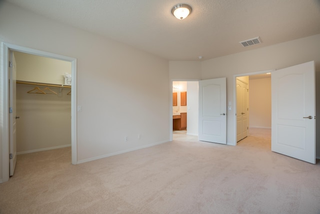 827 Purple Aster Dr, Bernalillo, NM 87004 - unfurnished bedroom with a walk in closet, light colored carpet, and ensuite bath