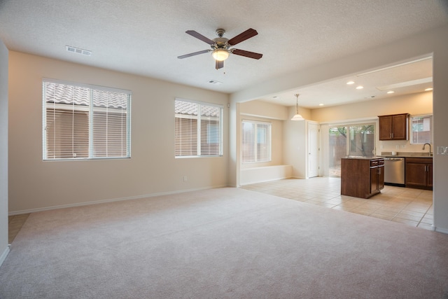 827 Purple Aster Dr, Bernalillo, NM 87004 - unfurnished living room with light colored carpet, ceiling fan, light tile patterned floors, recessed lighting, and a textured ceiling