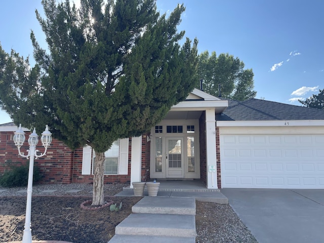 45 Juniper Ave, Los Lunas, NM 87031 - view of front of property with concrete driveway, an attached garage, brick siding, and a shingled roof