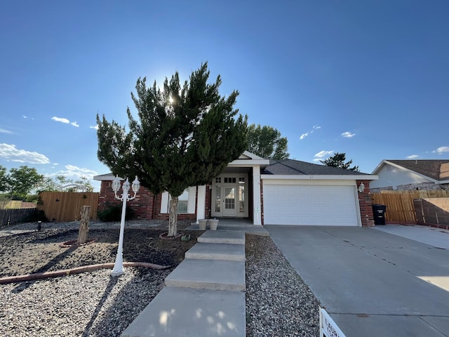 45 Juniper Ave, Los Lunas, NM 87031 - view of front facade featuring brick siding, concrete driveway, and a garage