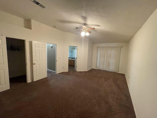 45 Juniper Ave, Los Lunas, NM 87031 - unfurnished bedroom with dark colored carpet, a walk in closet, connected bathroom, a closet, and lofted ceiling
